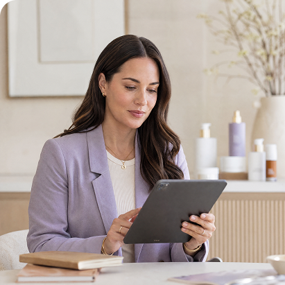 Woman in a lavender blazer reviewing a skincare tablet